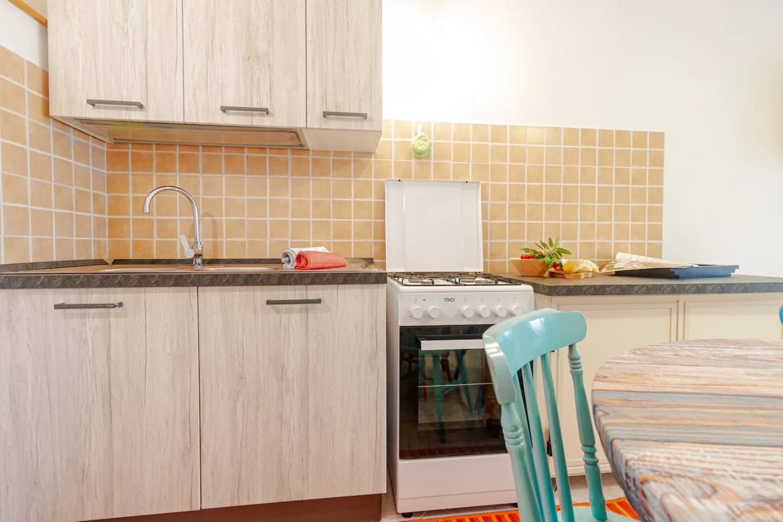Cucina attrezzata con piano cottura, forno e lavello.